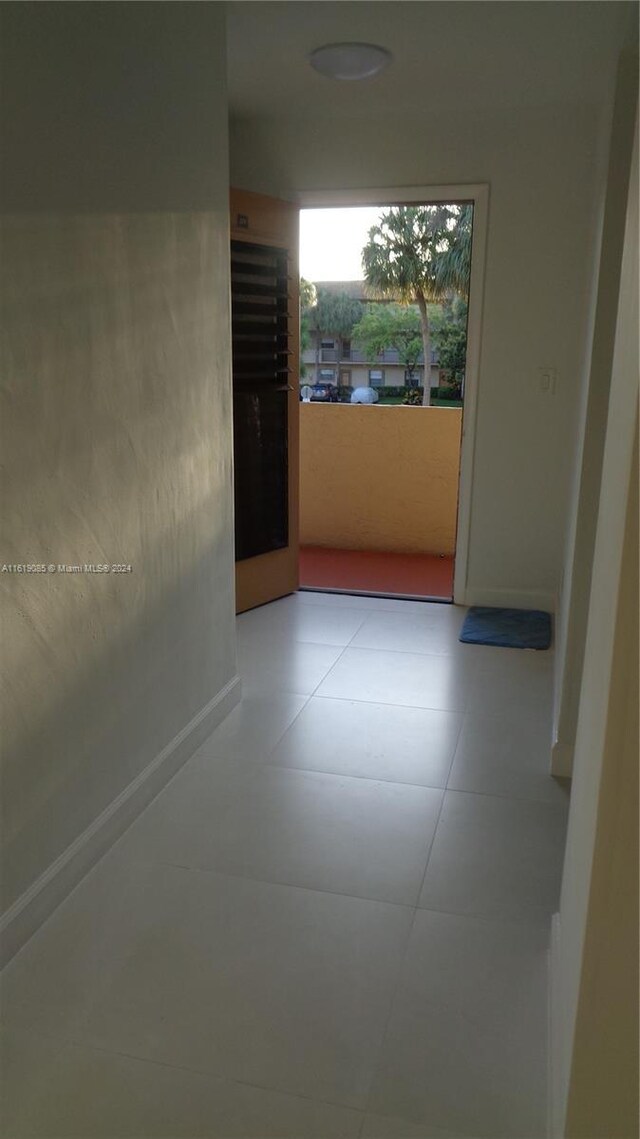 hall with tile patterned floors