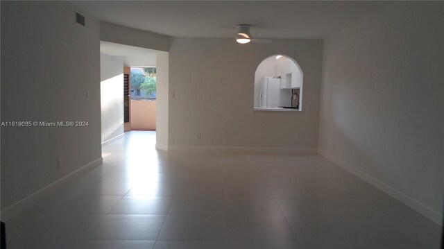 tiled empty room with ceiling fan