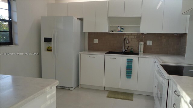 kitchen with white cabinetry, white appliances, and backsplash