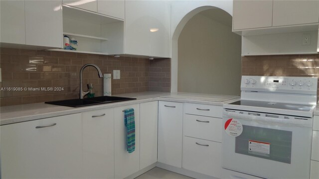 kitchen with sink, white cabinetry, electric range, and tasteful backsplash