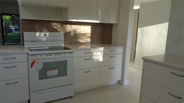 kitchen with white cabinetry, electric stove, and decorative backsplash