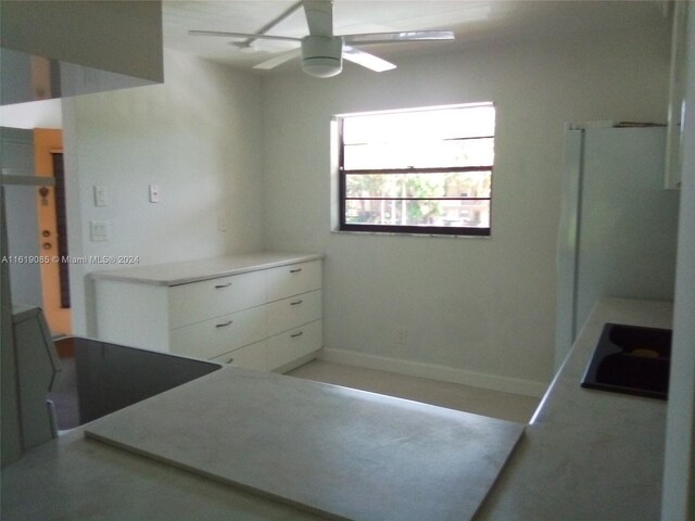 interior space with white fridge and ceiling fan