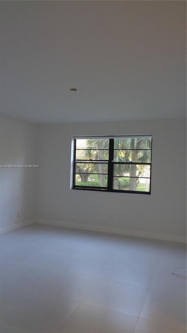 tiled spare room featuring plenty of natural light