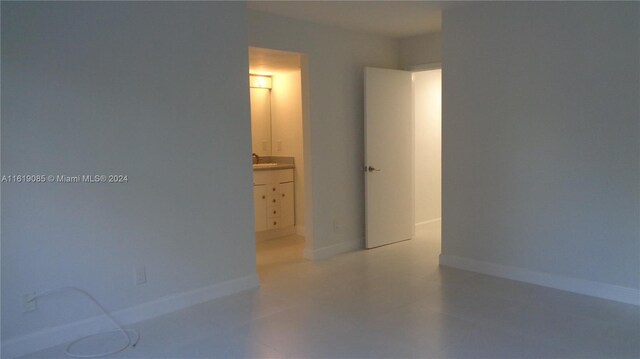 bedroom featuring ensuite bathroom and sink