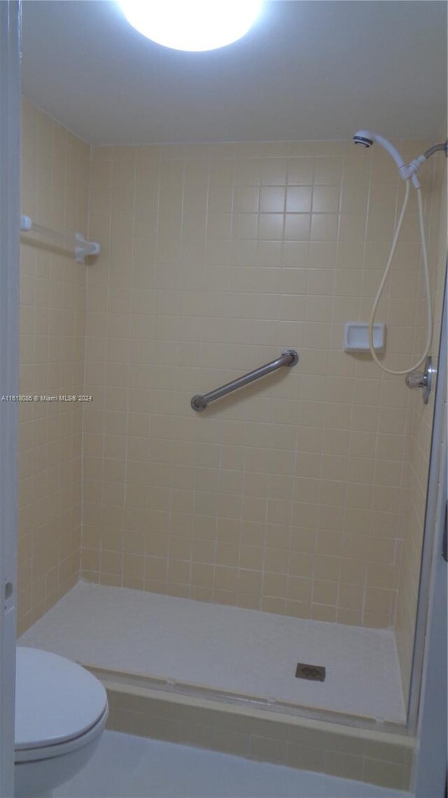 bathroom with tiled shower and toilet