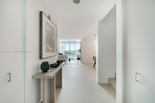 corridor with a wall of windows and concrete flooring