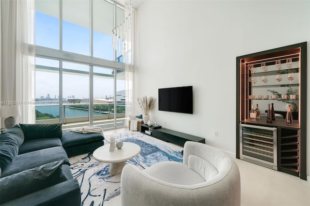 carpeted living area with beverage cooler, a dry bar, and a towering ceiling