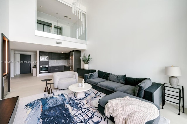 living area featuring visible vents and a high ceiling