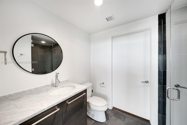 bathroom featuring vanity, toilet, visible vents, and a stall shower