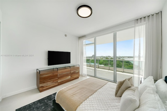 bedroom featuring access to exterior, baseboards, and concrete flooring