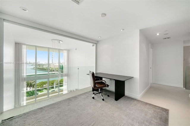 carpeted office space featuring floor to ceiling windows, visible vents, recessed lighting, and baseboards