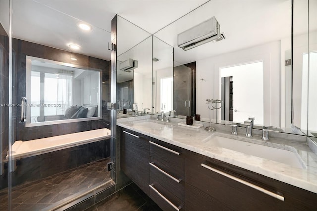 full bath with a shower stall, double vanity, a wall mounted air conditioner, and a sink