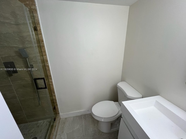 bathroom with vanity, toilet, tile patterned flooring, and an enclosed shower