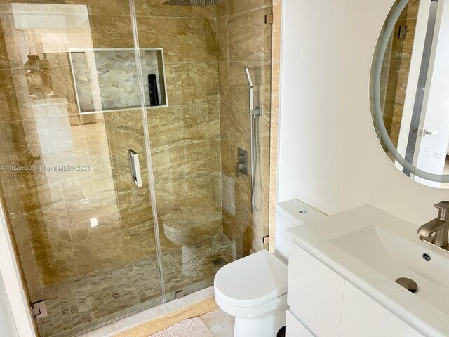 bathroom featuring tile patterned floors, vanity, an enclosed shower, and toilet