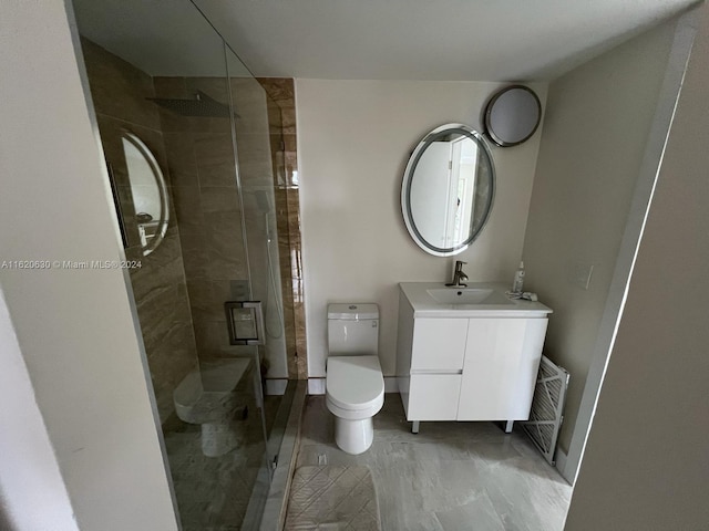 bathroom with vanity, tile patterned floors, a tile shower, and toilet