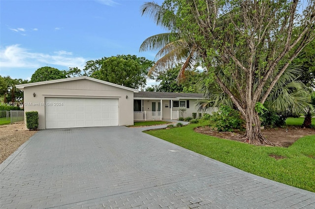 ranch-style house with a garage, covered porch, and a front lawn