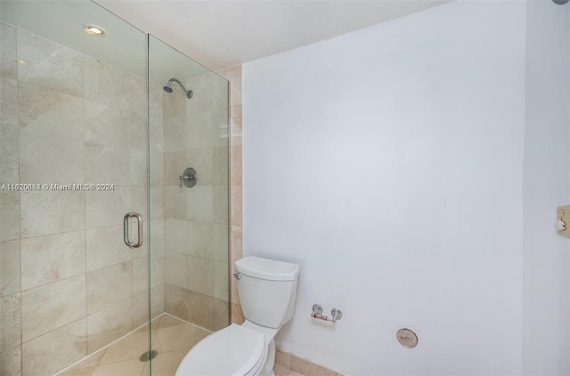 bathroom featuring toilet and an enclosed shower