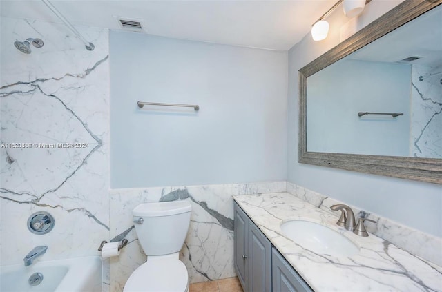 full bathroom featuring vanity, tiled shower / bath, tile walls, and toilet