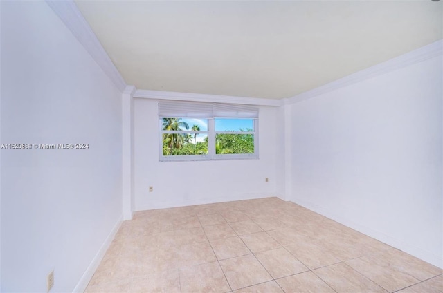 spare room featuring light tile patterned flooring and crown molding