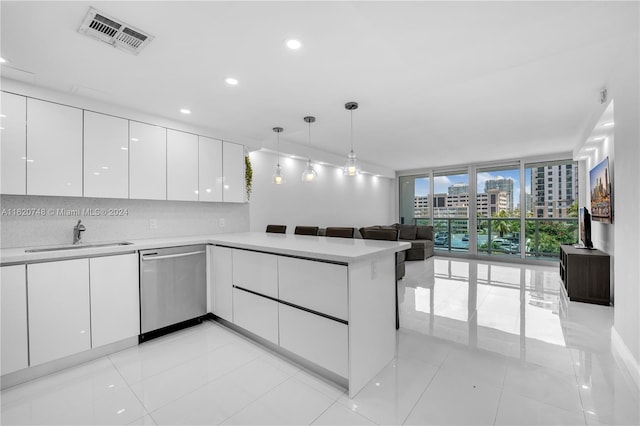 100 Bayview Dr Unit 430, Sunny Isles Beach, FL 33160 - kitchen with dishwasher, modern cabinets, white cabinets, a wall of windows, and a peninsula