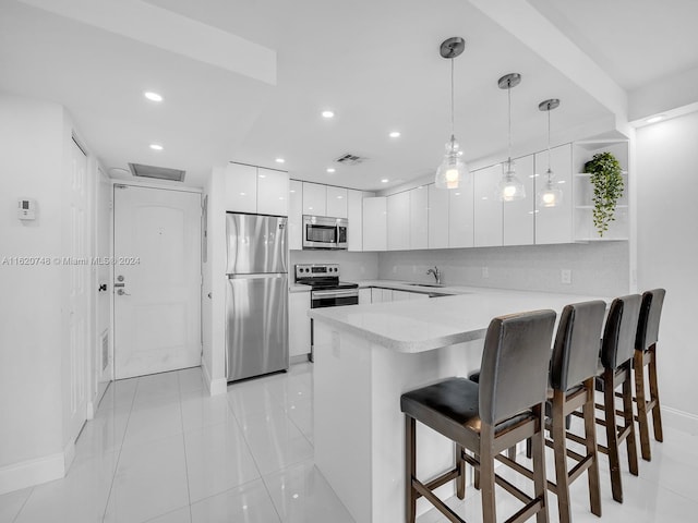 100 Bayview Dr Unit 430, Sunny Isles Beach, FL 33160 - kitchen featuring stainless steel appliances, a peninsula, modern cabinets, white cabinets, and a breakfast bar