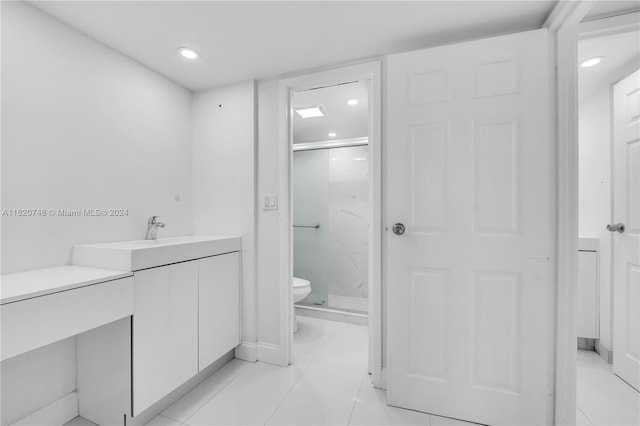 bathroom with vanity, tile patterned flooring, toilet, and an enclosed shower