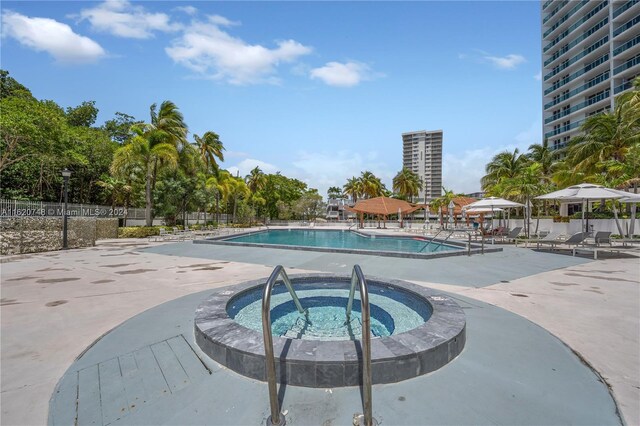 view of swimming pool featuring a community hot tub and a patio