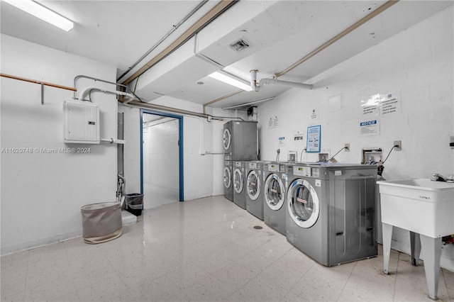 100 Bayview Dr Unit 430, Sunny Isles Beach, FL 33160 - community laundry with electric panel, washing machine and dryer, tile patterned floors, and stacked washer and clothes dryer