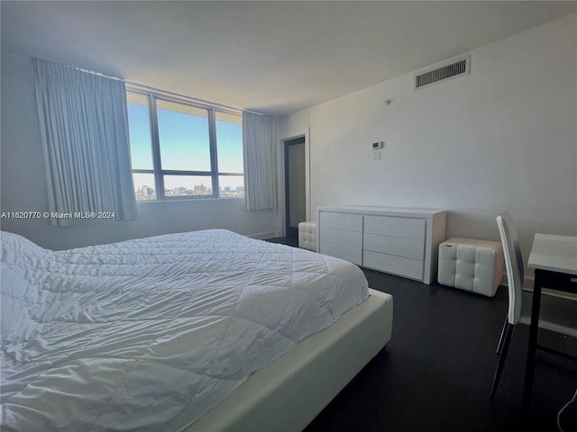 bedroom with dark hardwood / wood-style flooring