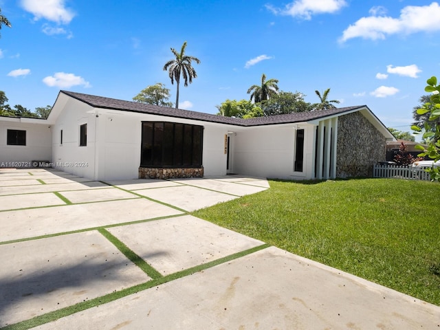 view of front of home with a front lawn and a patio