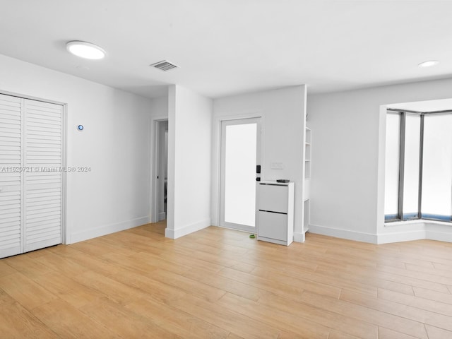 unfurnished bedroom featuring multiple windows and light hardwood / wood-style floors