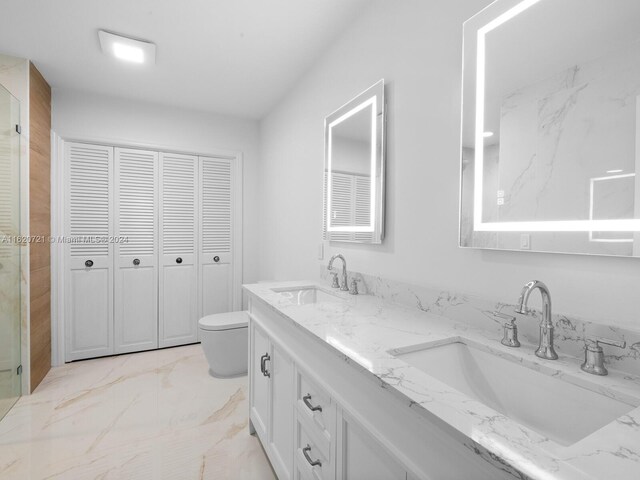 bathroom featuring vanity, toilet, and a shower with shower door