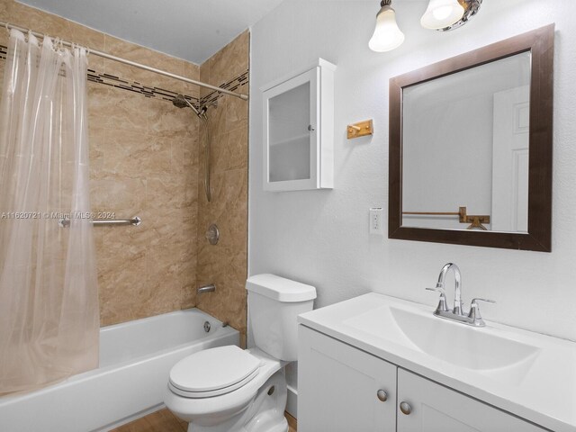 full bathroom featuring shower / bath combo, toilet, and vanity