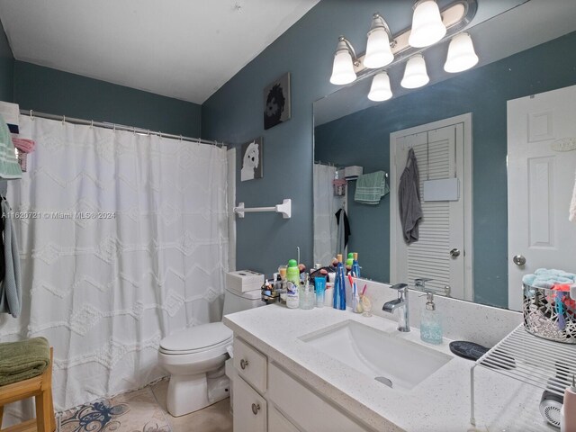 bathroom with tile patterned flooring, vanity, toilet, and walk in shower