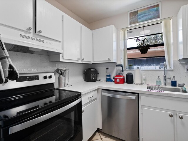 kitchen featuring light tile patterned floors, appliances with stainless steel finishes, tasteful backsplash, sink, and white cabinets