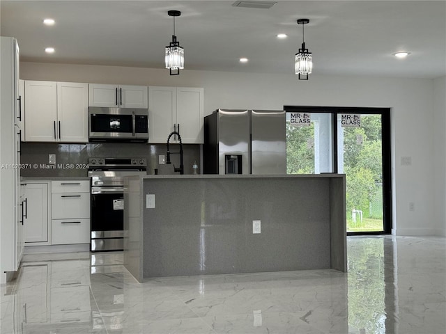 kitchen with tasteful backsplash, stainless steel appliances, hanging light fixtures, and white cabinets