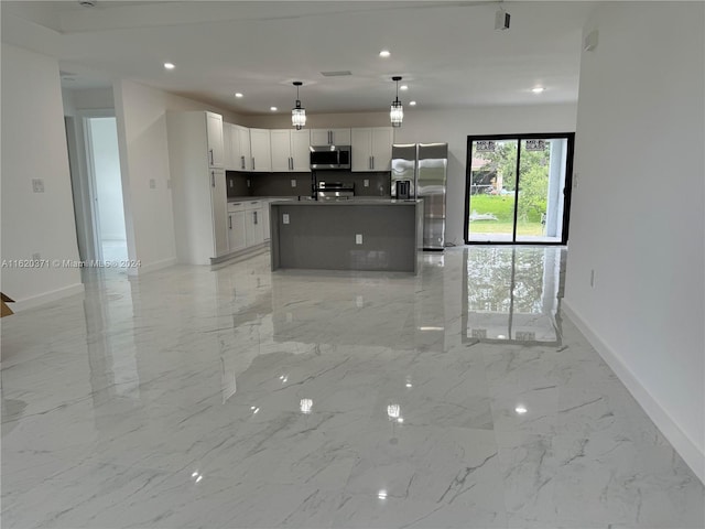 kitchen with a center island with sink, white cabinetry, stainless steel appliances, and pendant lighting