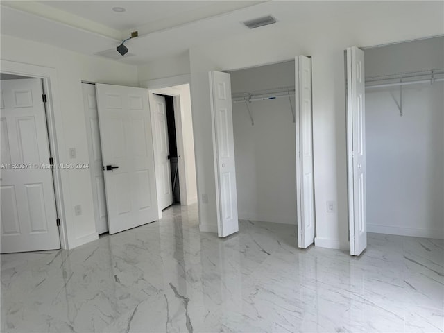 unfurnished bedroom featuring multiple closets