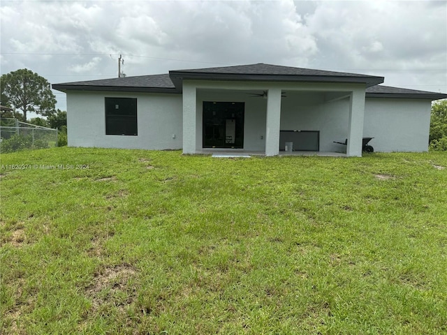 rear view of property with a patio and a lawn