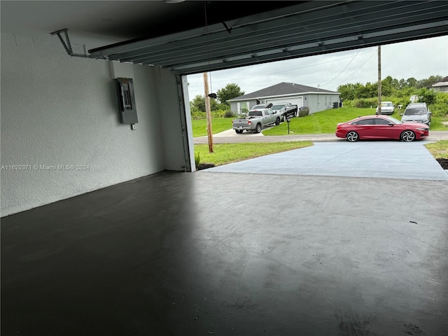 garage with electric panel and a lawn