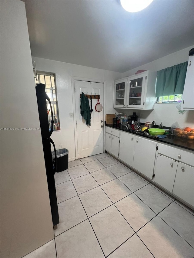 kitchen with plenty of natural light, white cabinets, and light tile patterned floors