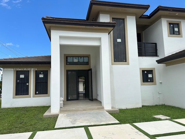 doorway to property featuring a lawn