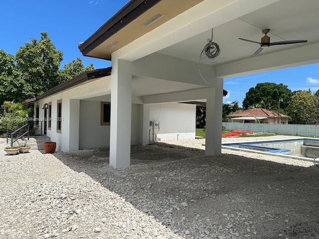 exterior space featuring ceiling fan and a fenced in pool