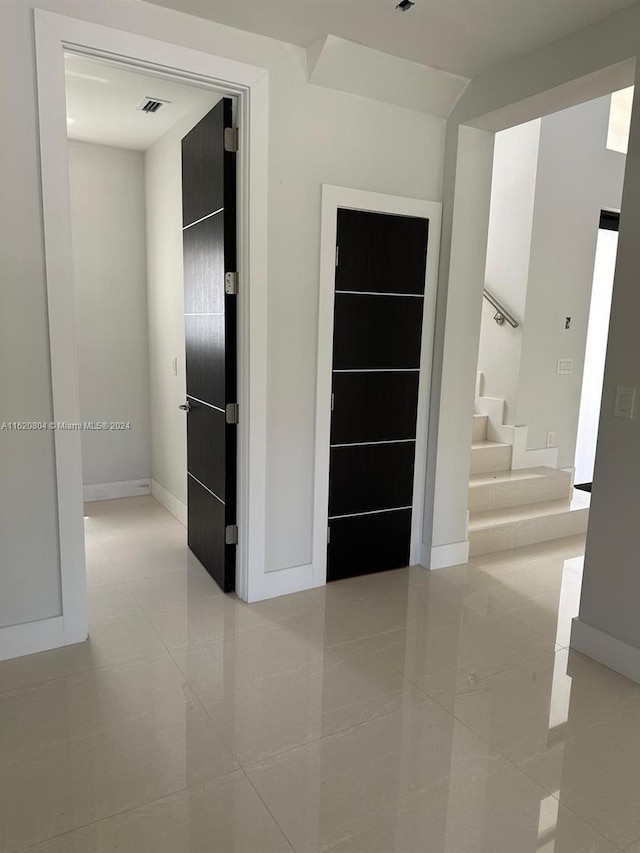 corridor featuring light tile patterned floors