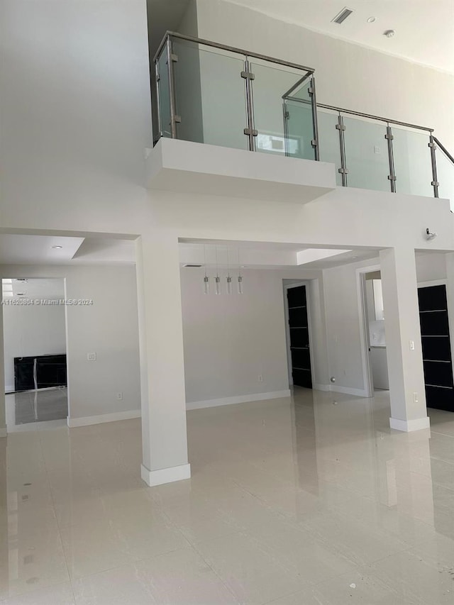 interior space featuring light tile patterned flooring and a towering ceiling