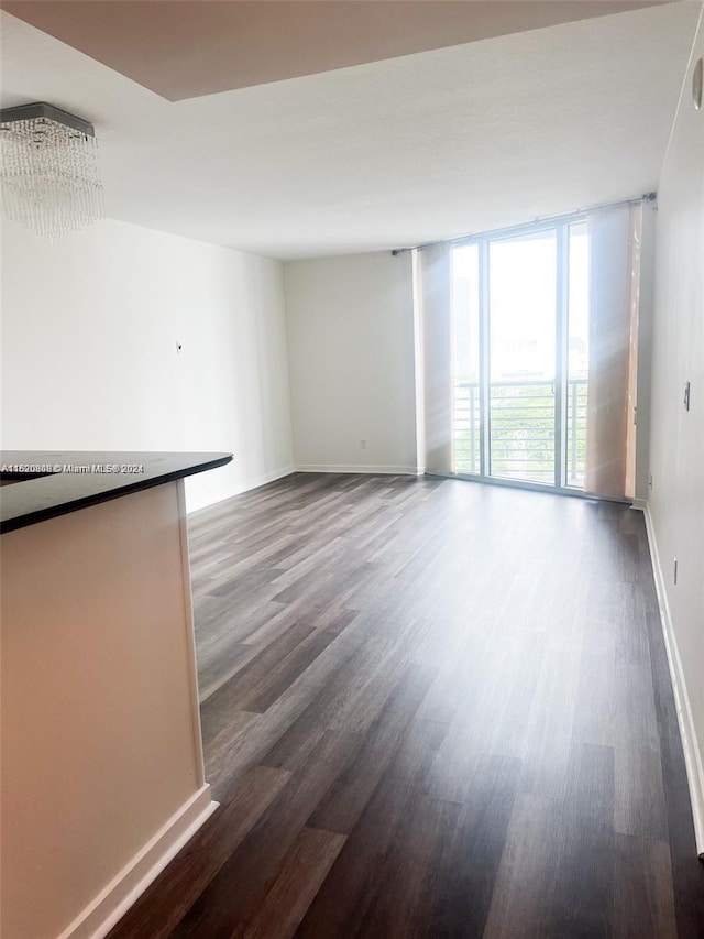 unfurnished living room with dark hardwood / wood-style floors and a wall of windows