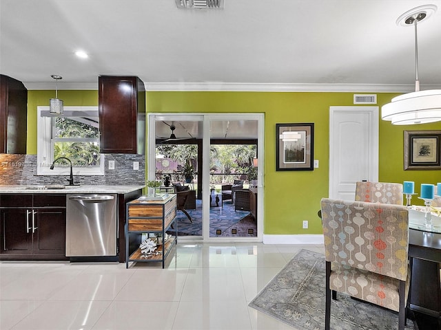 kitchen with plenty of natural light, stainless steel dishwasher, pendant lighting, and light tile patterned floors