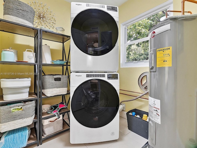 laundry room with stacked washer and clothes dryer, water heater, and tile patterned flooring