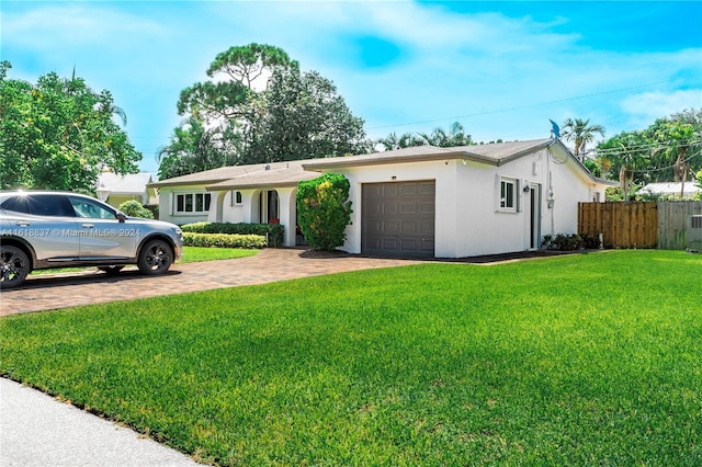 ranch-style home featuring a garage and a front lawn