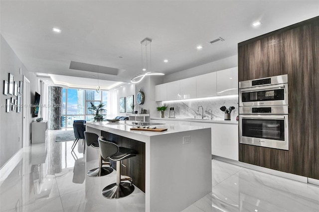 kitchen with light tile patterned flooring, dark brown cabinets, pendant lighting, white cabinets, and stainless steel double oven